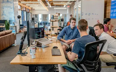 Team meeting around a desk in a workspace